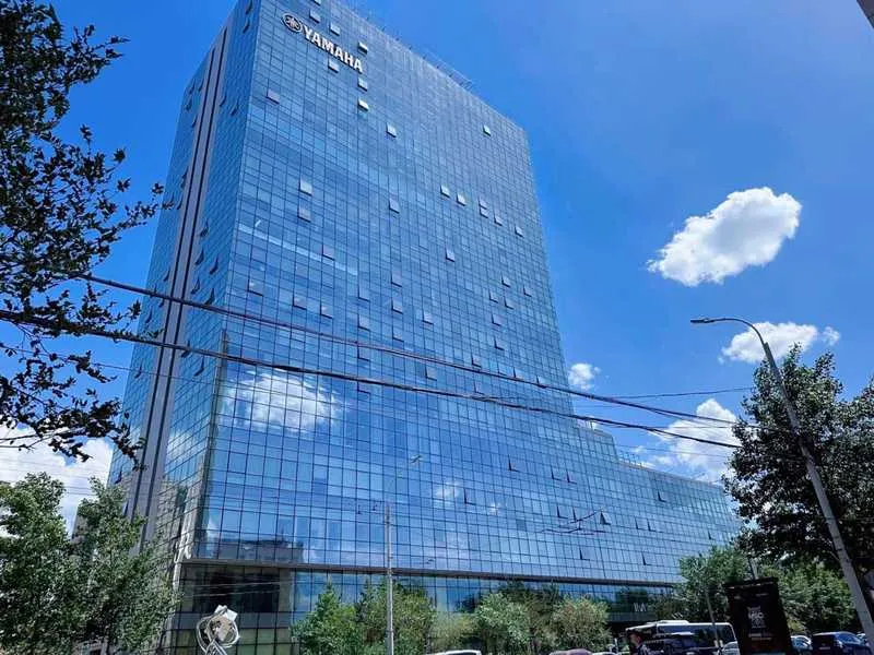 Regis Place's blue reflective glass façade mirroring the sky