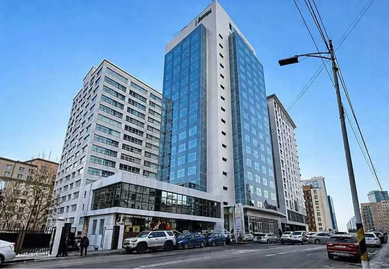 UB Tower's blue glass façade seen from street level by day